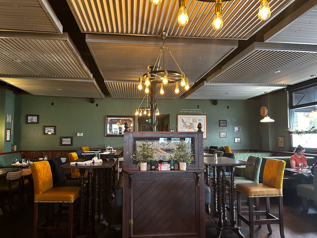 gold and green decor in a bar with tables and chairs